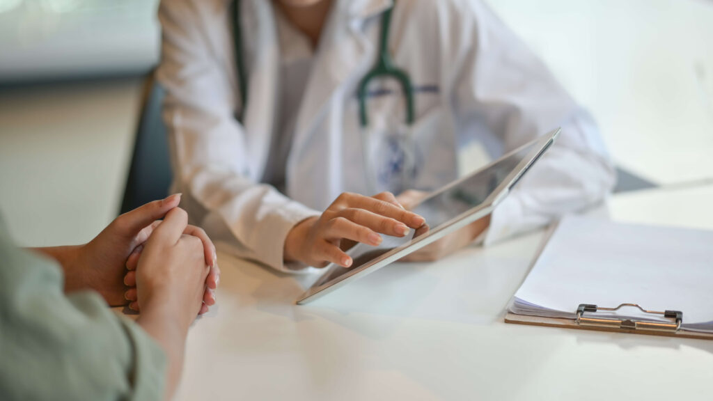 A doctor reviewing a patient's information on a tablet
