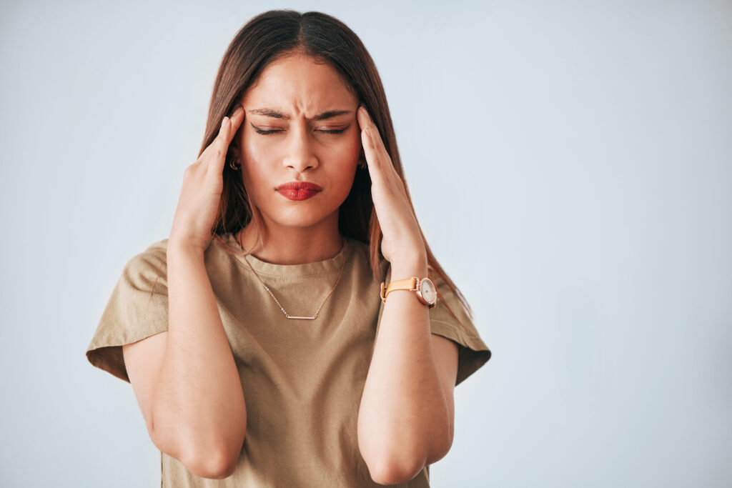 A woman suffering from brain fog is holding her head in her hands
